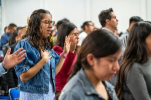 Adults gathered in prayer during a church service in Ciudad de México, México.